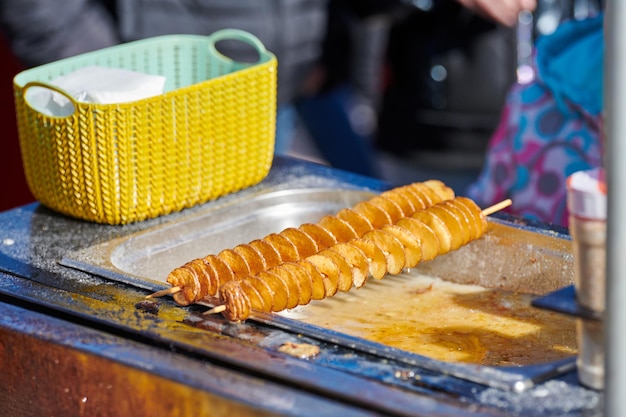 Patata frita en espiral cocida en aceite hirviendo rica en grasas y calorías comida rápida insalubre deliciosa