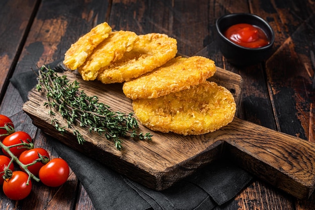 Patata hash brown Empanadas de patata en una tabla de madera con salsa de tomate Fondo de madera Vista superior