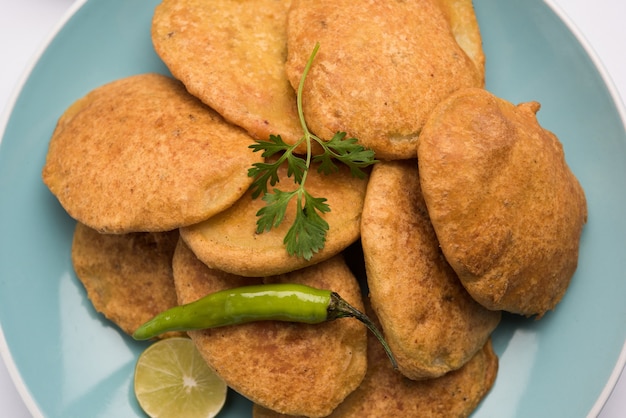 Patata o aloo pakora o pakode o aloo bhajji servido con salsa de tomate, té verde frito frío y caliente, aperitivo indio popular de todos los tiempos, servido sobre hoja de coco fresca, enfoque selectivo