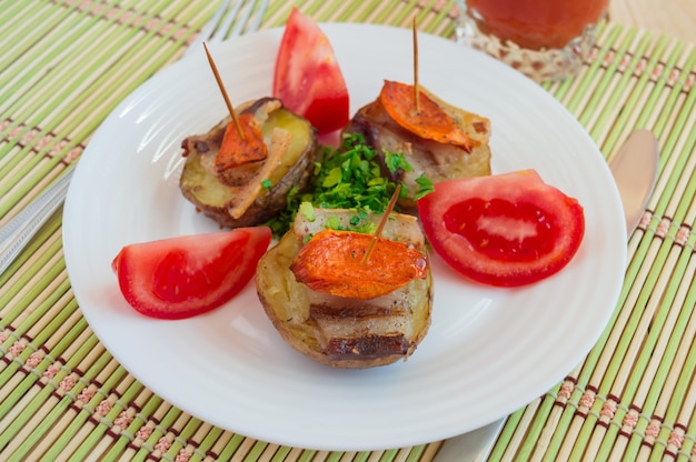 Patatas al horno en casa con verduras y tomate