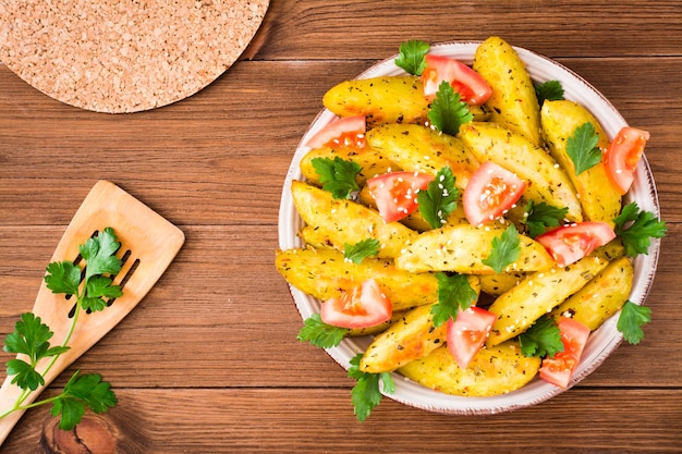 Patatas al horno en una cáscara con tomates, hierbas, especias y sésamo en un plato, Vista superior