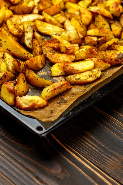 Foto patatas al horno con especias y bandeja para hornear sal