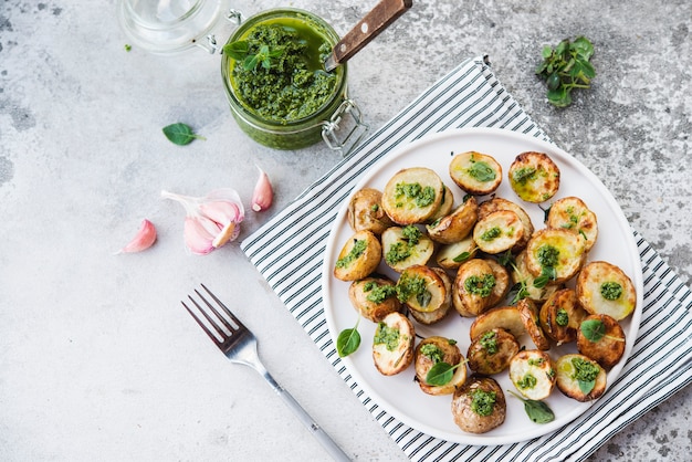 Patatas al horno en estilo rústico con salsa de pesto verde