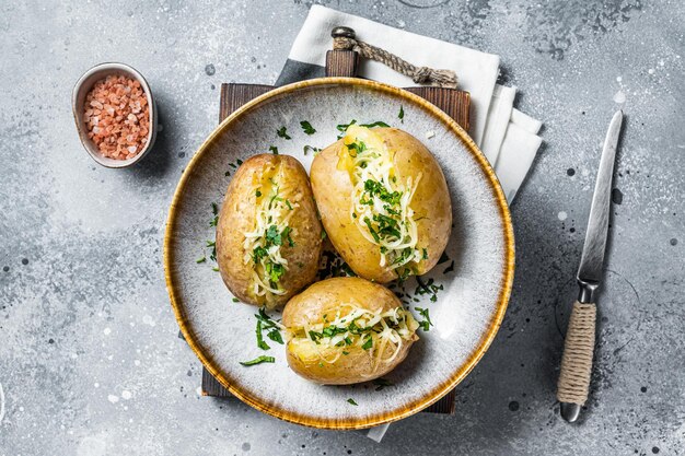 Patatas al horno con queso y mantequilla Fondo gris Vista superior