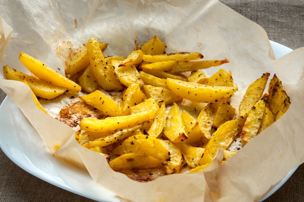 Patatas asadas con romero sobre papel de fondo