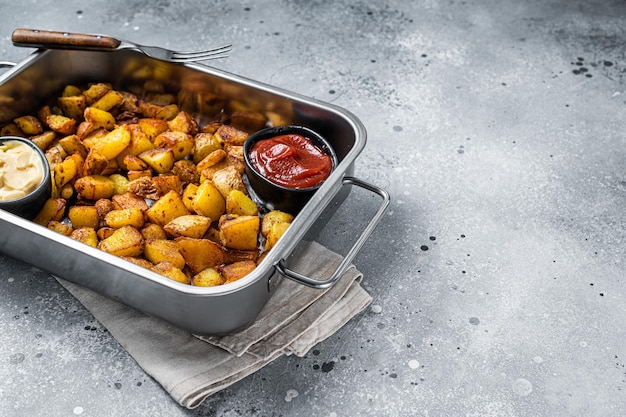 Patatas bravas batatas tradicionais espanholas petiscos em uma bandeja de aço. plano de fundo cinza. vista do topo. copie o espaço.