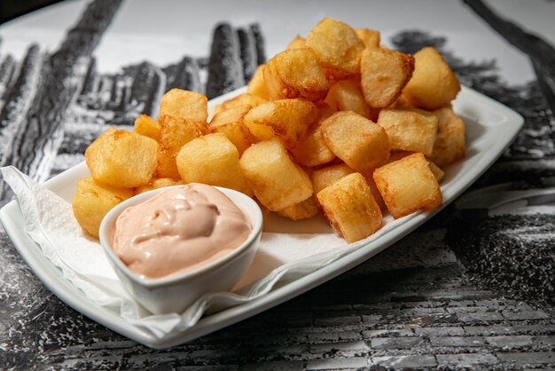 Patatas bravas con salsa servidas en un plato