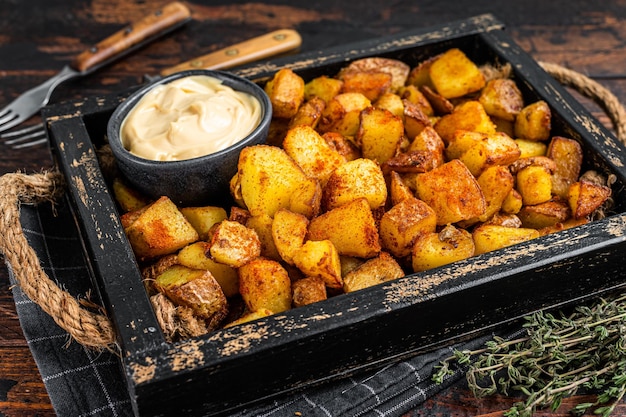 Patatas bravas tradicionales patatas españolas snack tapas. fondo de madera oscura. vista superior.