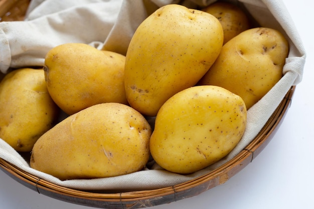 Patatas crudas en cesta de bambú