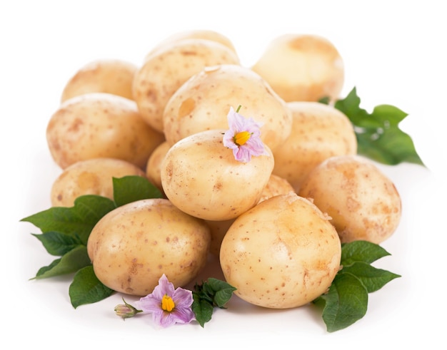 Patatas crudas con flores y hojas aisladas sobre fondo blanco.