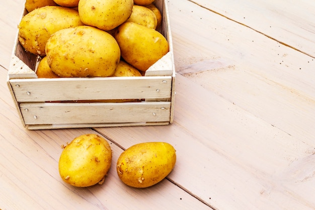 Patatas crudas frescas en caja de madera