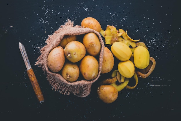 Patatas crudas sobre un fondo de madera negra Cocinar Espacio libre para texto Vista superior