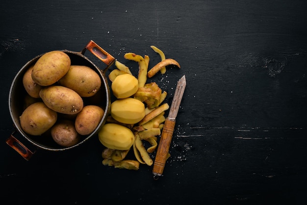 Patatas crudas sobre un fondo de madera negra Cocinar Espacio libre para texto Vista superior