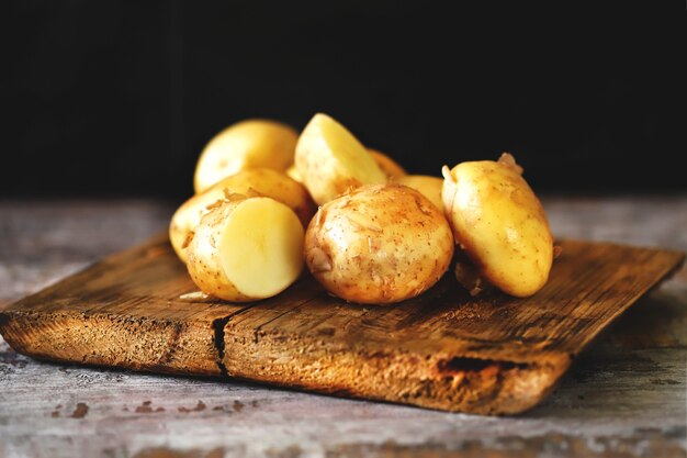 Foto patatas crudas sobre una superficie de madera