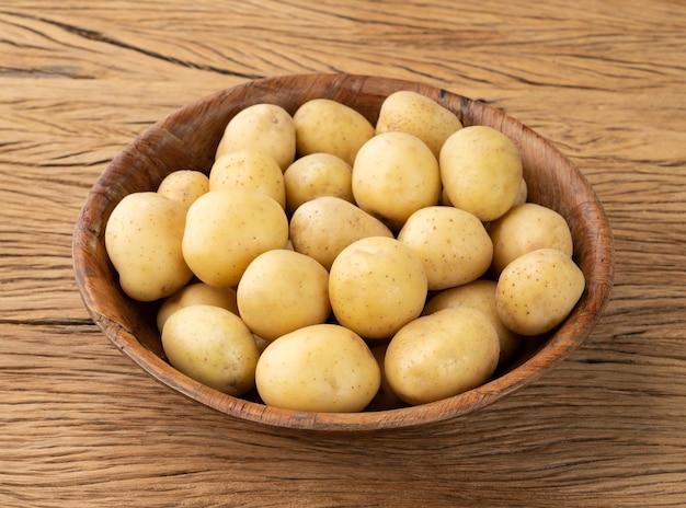 Patatas diminutas en un bol sobre una mesa de madera