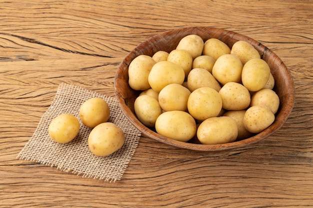 Patatas diminutas en un bol sobre una mesa de madera