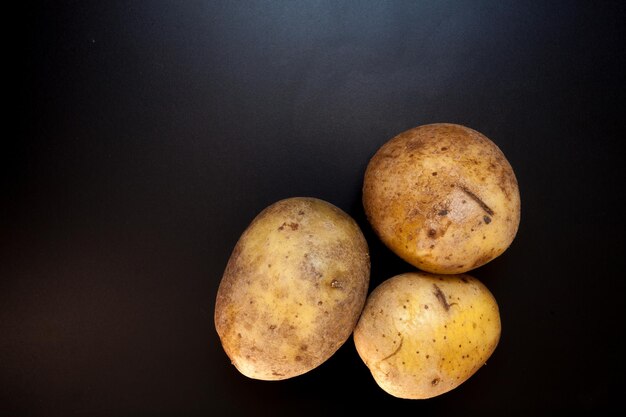 Patatas en fondo de comida de mesa negra Patatas aisladas