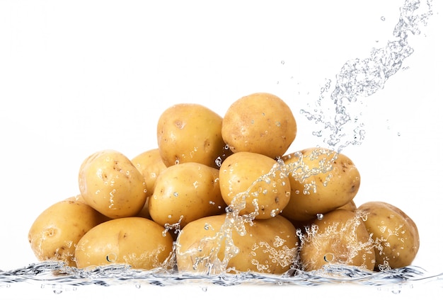 Patatas frescas cayendo en el agua