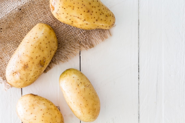 Patatas frescas sobre fondo de madera