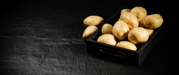 Foto patatas frescas sobre un fondo negro