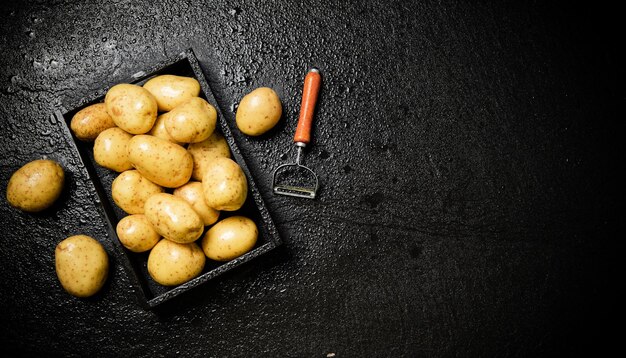 Foto patatas frescas sobre un fondo negro