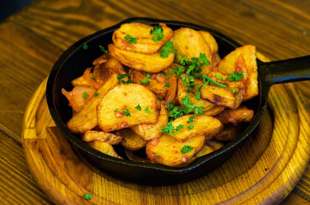 Patatas fritas al horno con ajo sobre fondo de mesa de madera