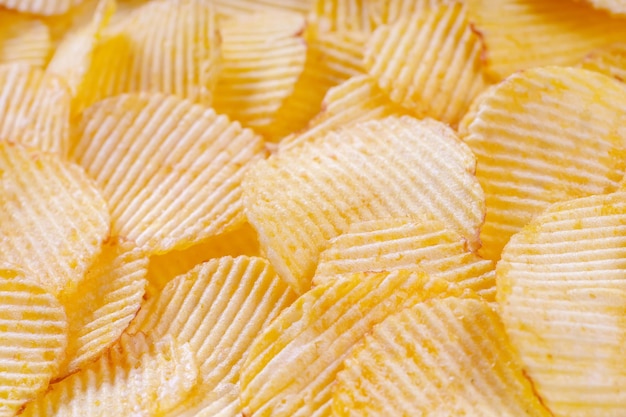 Patatas fritas amarillas crujientes con surcos de cerca Fondo de alimentos