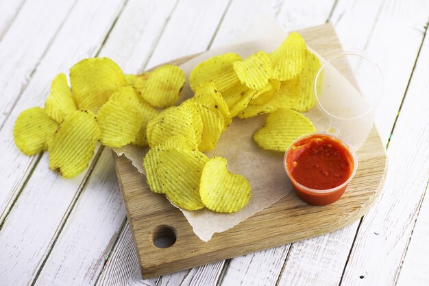 Patatas fritas en una bandeja de madera sobre una mesa blanca