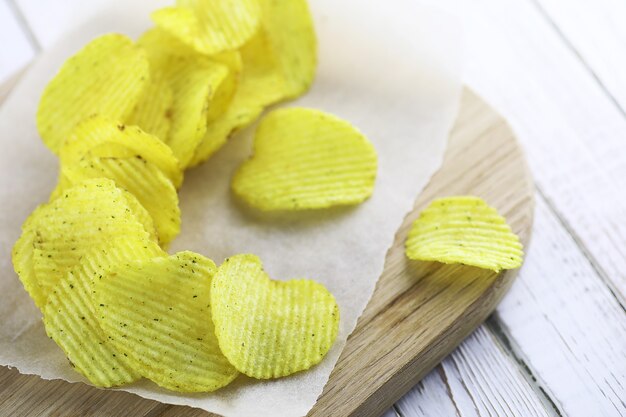 Patatas fritas en una bandeja de madera sobre una mesa blanca