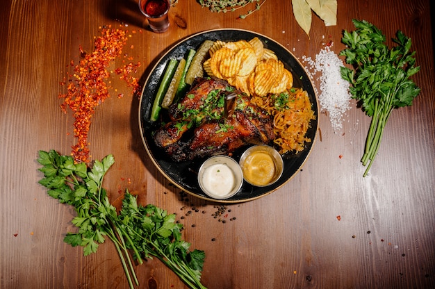 Patatas fritas con carne en un plato sobre una mesa de madera. Vista superior