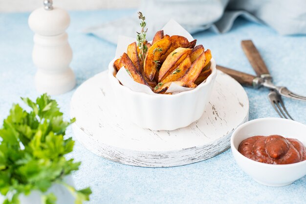 Patatas fritas caseras al horno con hierbas y salsa roja