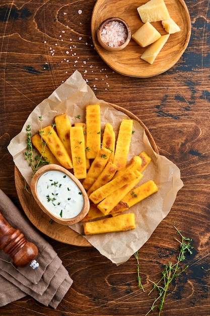 patatas fritas caseras de polenta con sal marina, parmesano, tomillo, romero con salsa de yogur