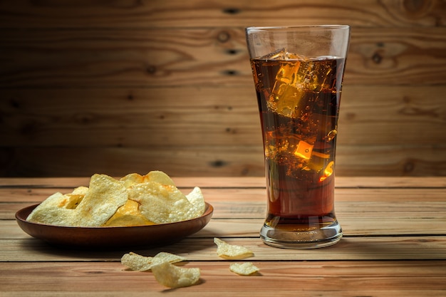 Patatas fritas con cola sobre un fondo de madera