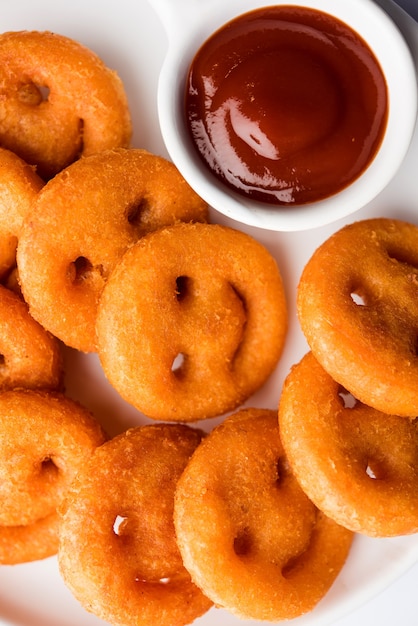 Patatas fritas crujientes con cara sonriente o bocadillos fritos con cara sonriente servidos con salsa de tomate