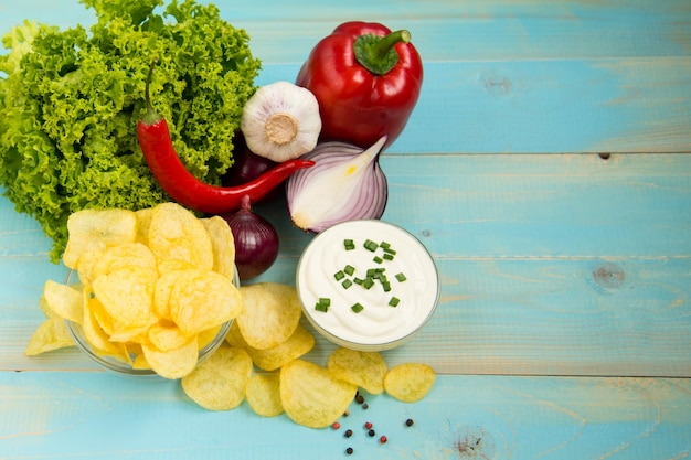 Foto patatas fritas crujientes en un recipiente de vidrio con ensalada de ajo picante y crema agria de cebolla