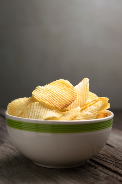 Patatas fritas en cuenco en fondo de madera de la tabla.