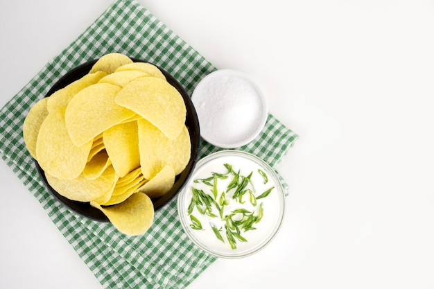 Patatas fritas en un cuenco de madera con crema agria y cebolla verde