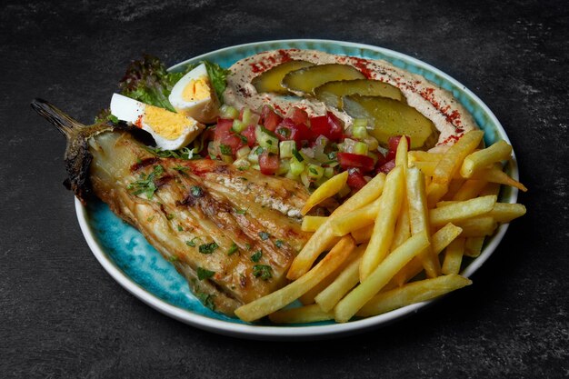 Patatas fritas con ensalada de verduras con huevos de berenjena al horno