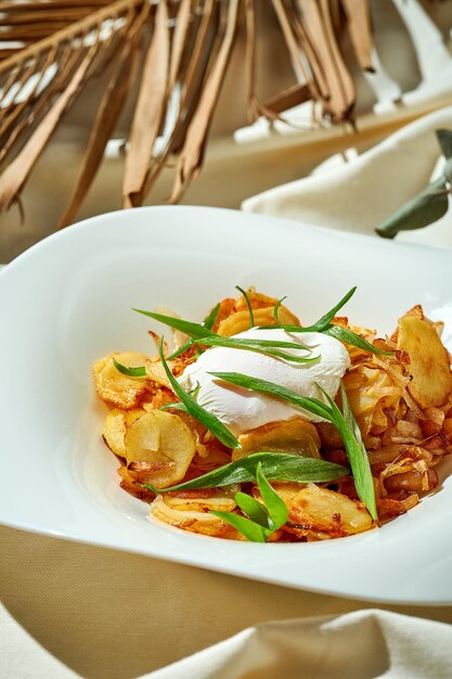 Patatas fritas con huevo escalfado en un plato Tough light Mantel blanco