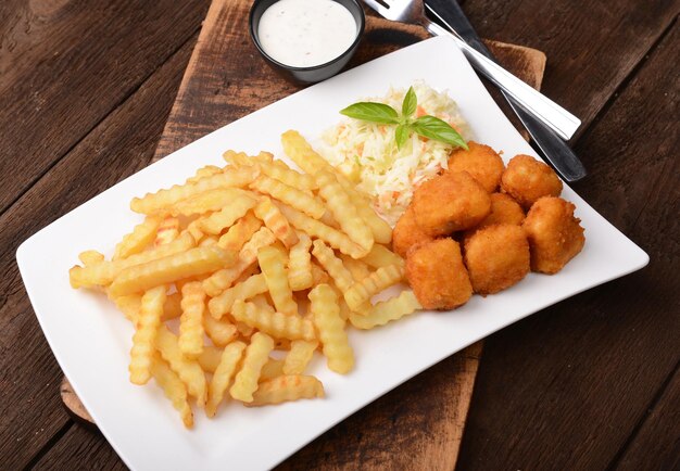 Patatas fritas con nuggets de pollo y ensalada