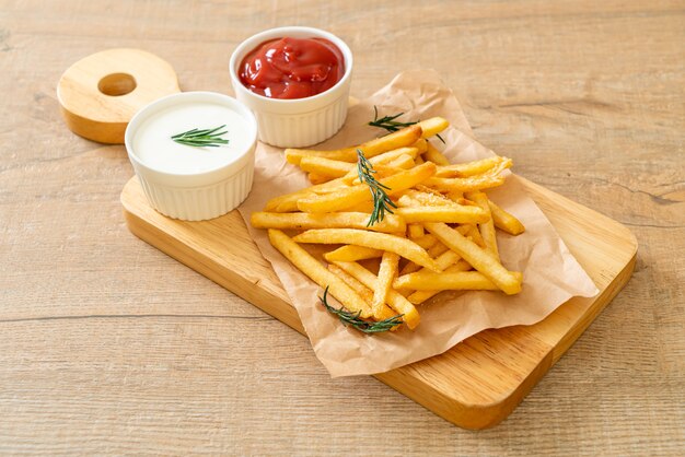 Patatas fritas o papas fritas con crema agria y ketchup