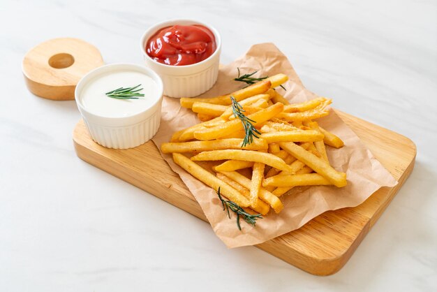 Patatas fritas o papas fritas con crema agria y ketchup