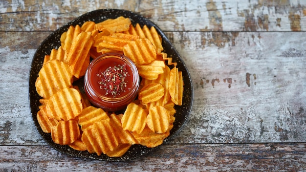 Patatas fritas en un plato y salsa roja