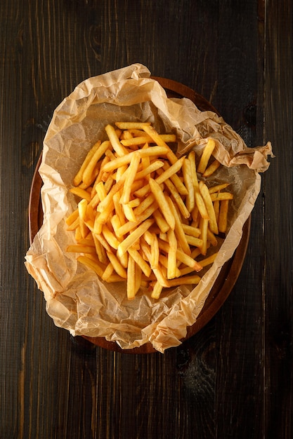 Patatas fritas en un plato sobre fondo rústico de madera