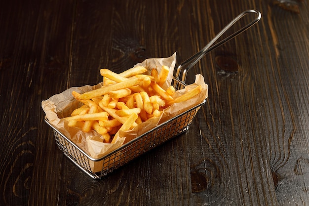 Patatas fritas en un plato sobre fondo rústico de madera