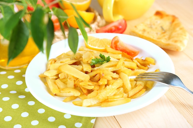 Patatas fritas en un plato sobre una mesa de madera de cerca