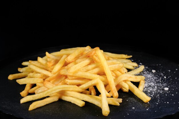 Patatas fritas en un primer plano de fondo oscuro comida rápida