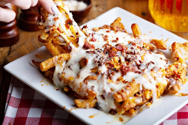 Foto patatas fritas con queso y tocino