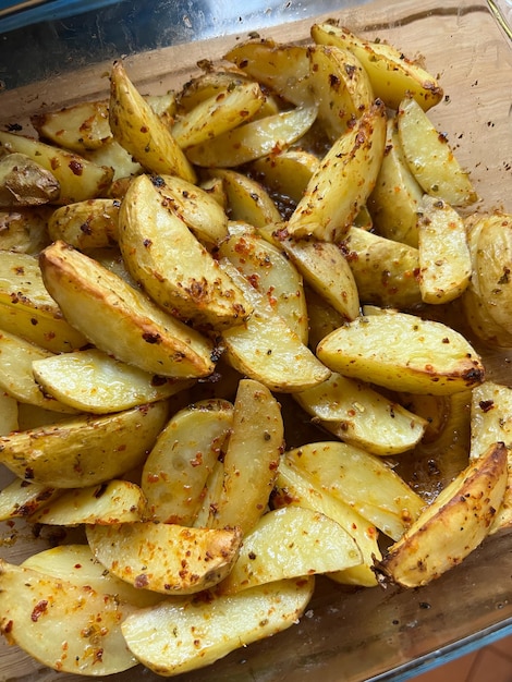 Patatas fritas rústicas con especias en un recipiente transparente