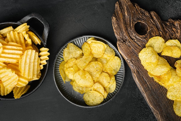 Patatas fritas con sabor a crema agria Cheddar sobre fondo de mesa de piedra oscura negra vista superior plana